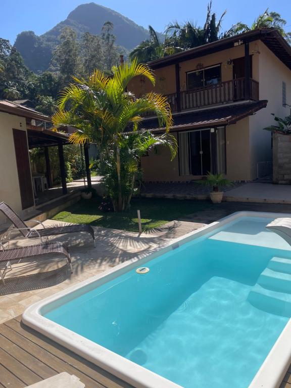 a villa with a swimming pool and a house at Refúgio em São Pedro da Serra in Nova Friburgo