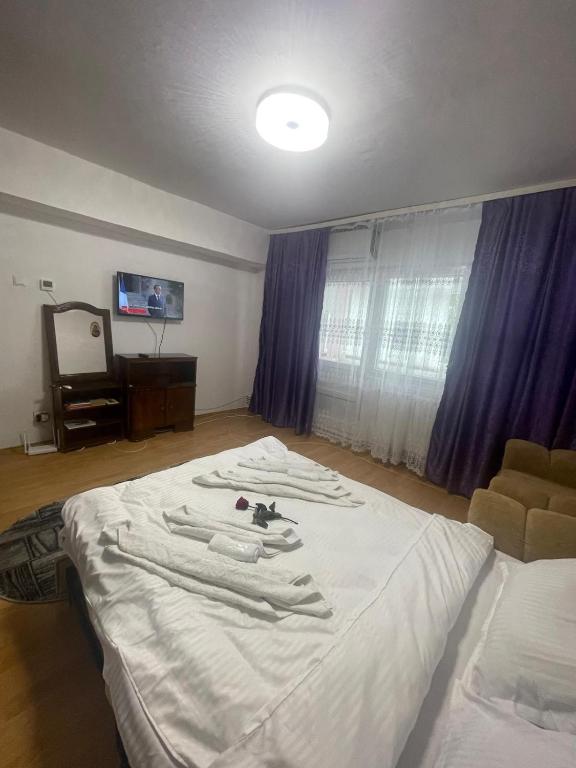 a bedroom with a white bed with clothes on it at Sky KATERINNA in Brăila