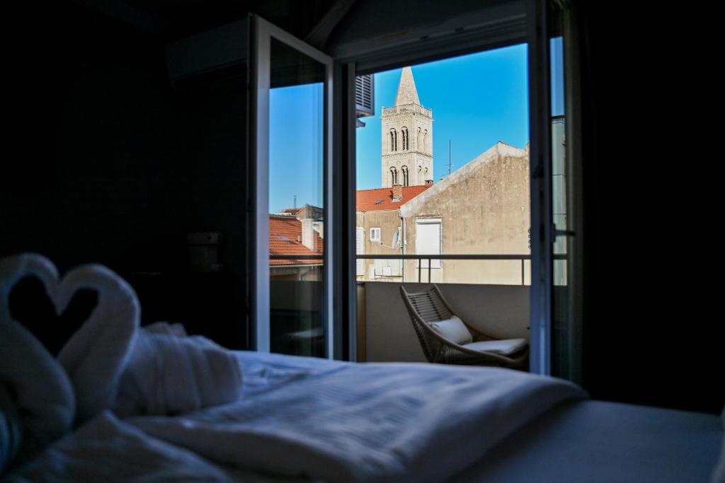 a bedroom with a bed and a view of a church at Luxury rooms Iva in Zadar