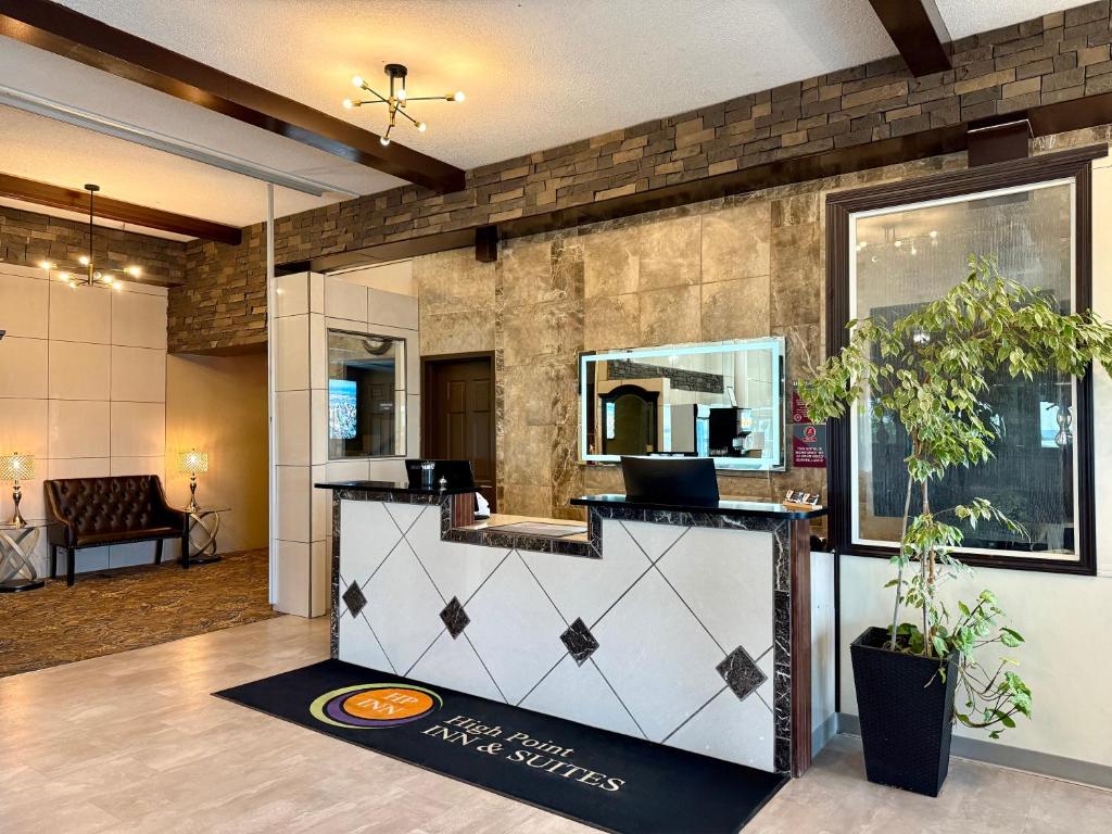 a lobby with a reception desk with a mirror at High Point Inn & Suites Peace River in Peace River