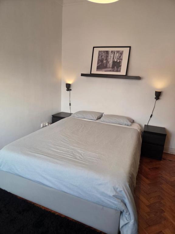 una camera con un grande letto con due lampade a muro di Parque das Nações Room a Lisbona