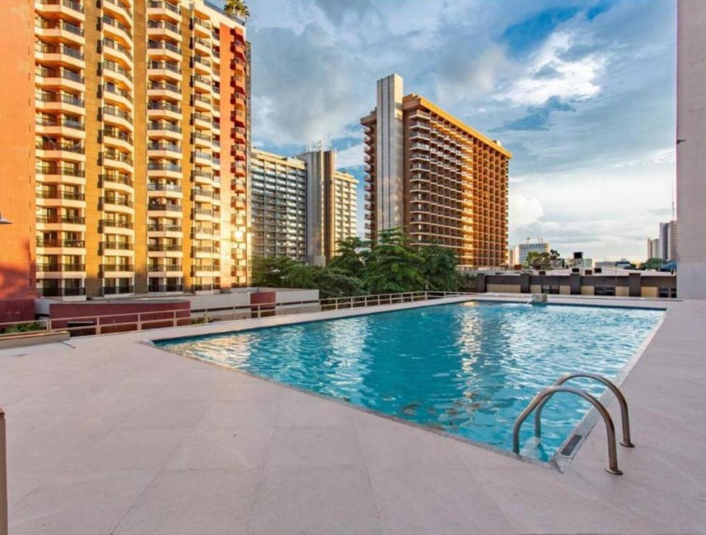 a swimming pool on the roof of a building with tall buildings at Garvey Hotel - Flat centro de Brasília in Brasilia
