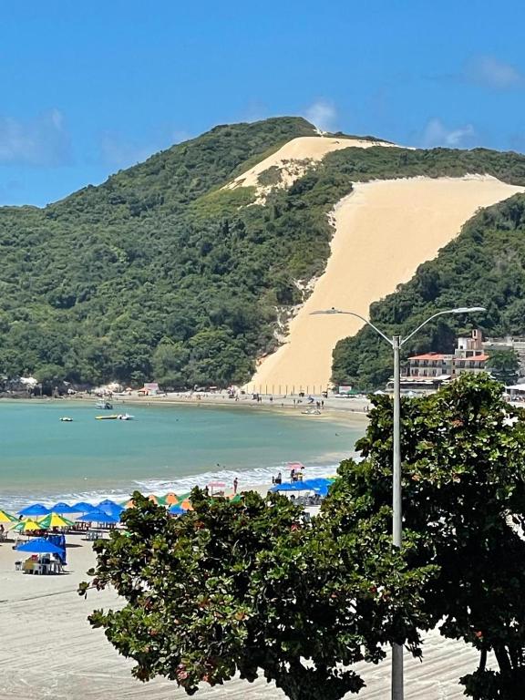a beach with umbrellas and a large sand hill at Bella Natal praia hotel in Natal