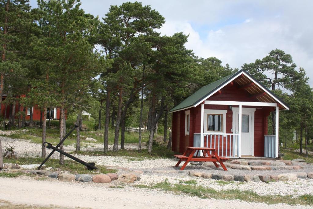 einen kleinen roten und weißen Schuppen mit einem Picknicktisch in der Unterkunft Kalana Holiday Resort in Kalana