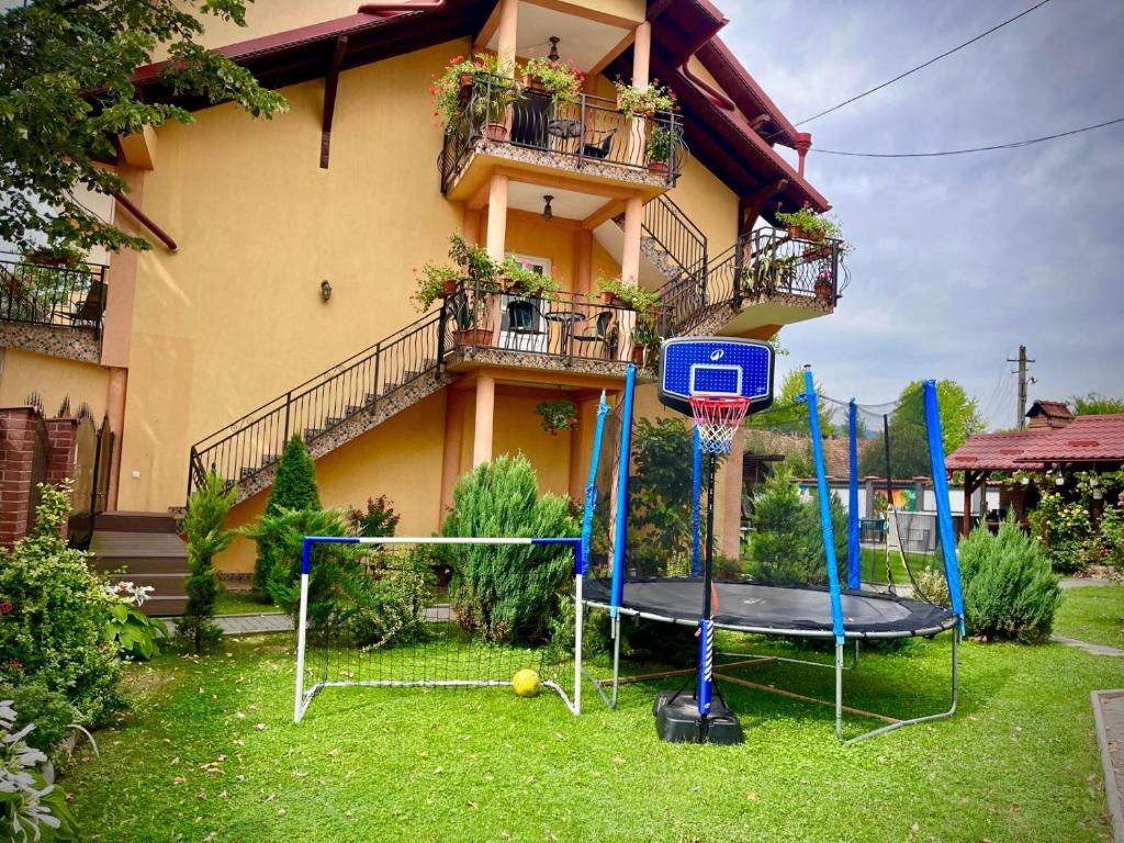 a house with a basketball hoop in front of a house at La Mateo in Călimăneşti