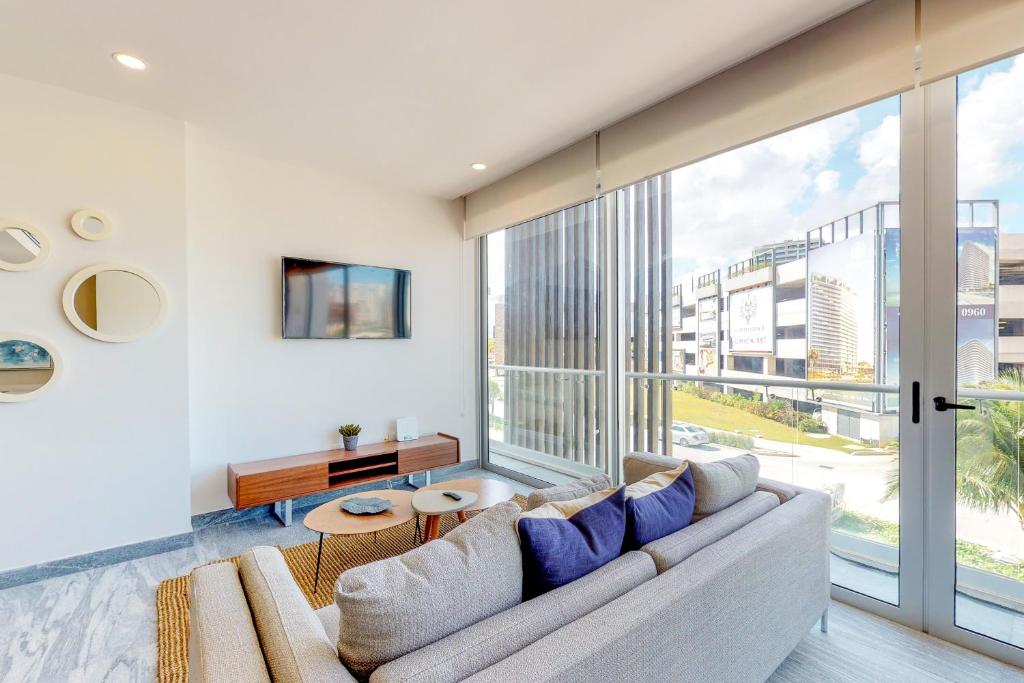 Una sala de estar con un sofá y una ventana grande. en Riva Puerto Cancun # 207, Halibut, en Cancún