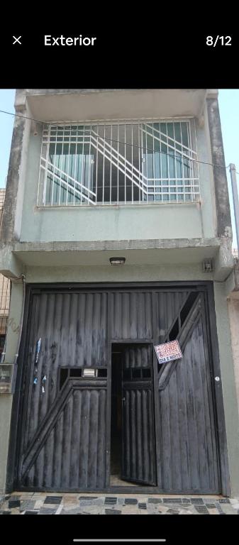 a building with a large wooden door with a sign on it at Quarto Pedreira Mauriti in Belém