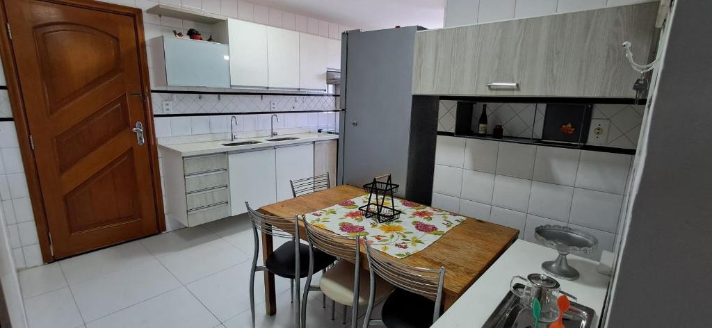 a small kitchen with a wooden table and chairs at Edifício Montpellier in Curro Velho