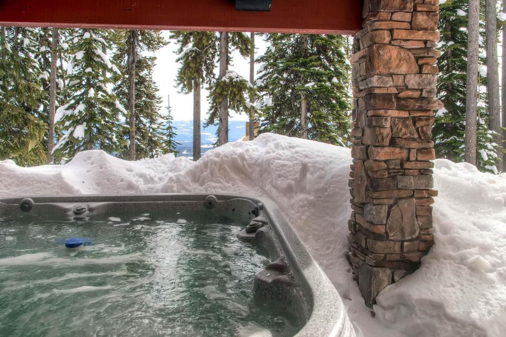 a hot tub covered in snow next to a building at Snowbanks 6 in Big White