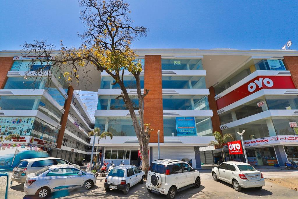 a parking lot with cars parked in front of a building at Hotel Infinity in Vadodara