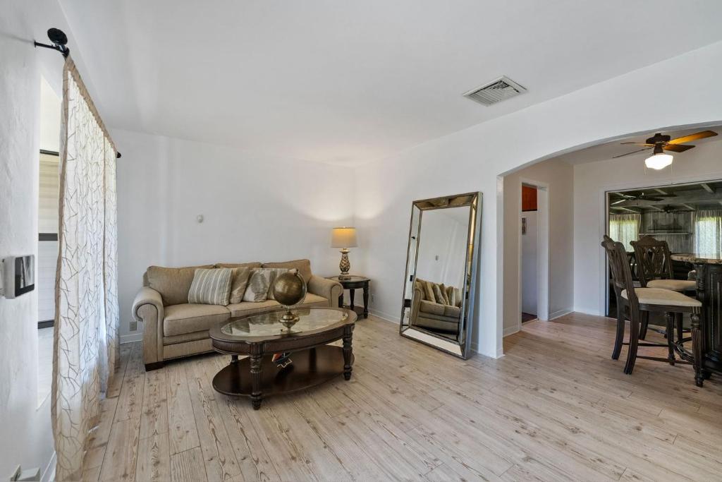 a living room with a couch and a table and a mirror at Sunset Place in West Palm Beach