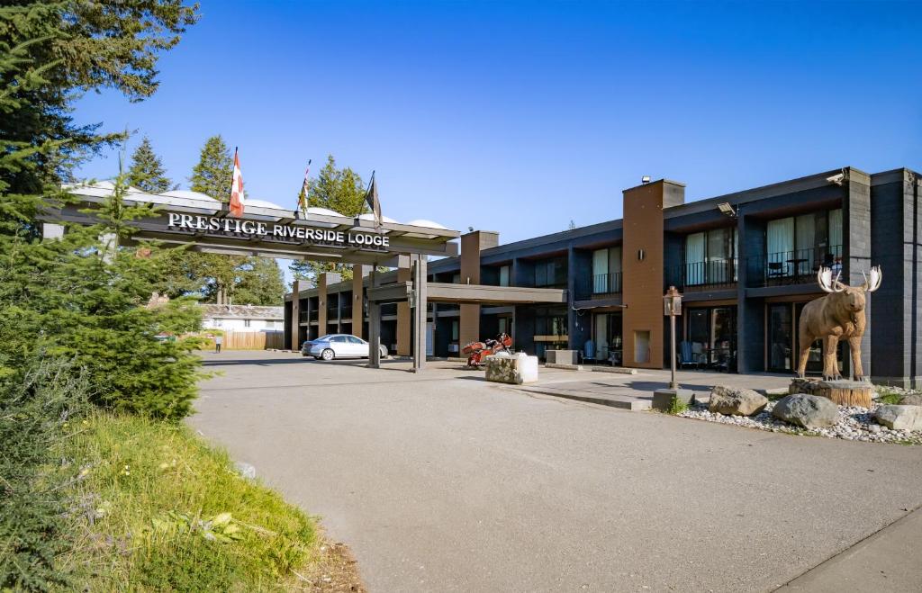 a building with a moose statue in front of it at Prestige Riverside Lodge Quesnel in Quesnel