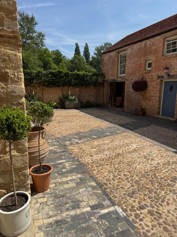 a courtyard with potted plants and a brick building at The Menagerie in Towcester