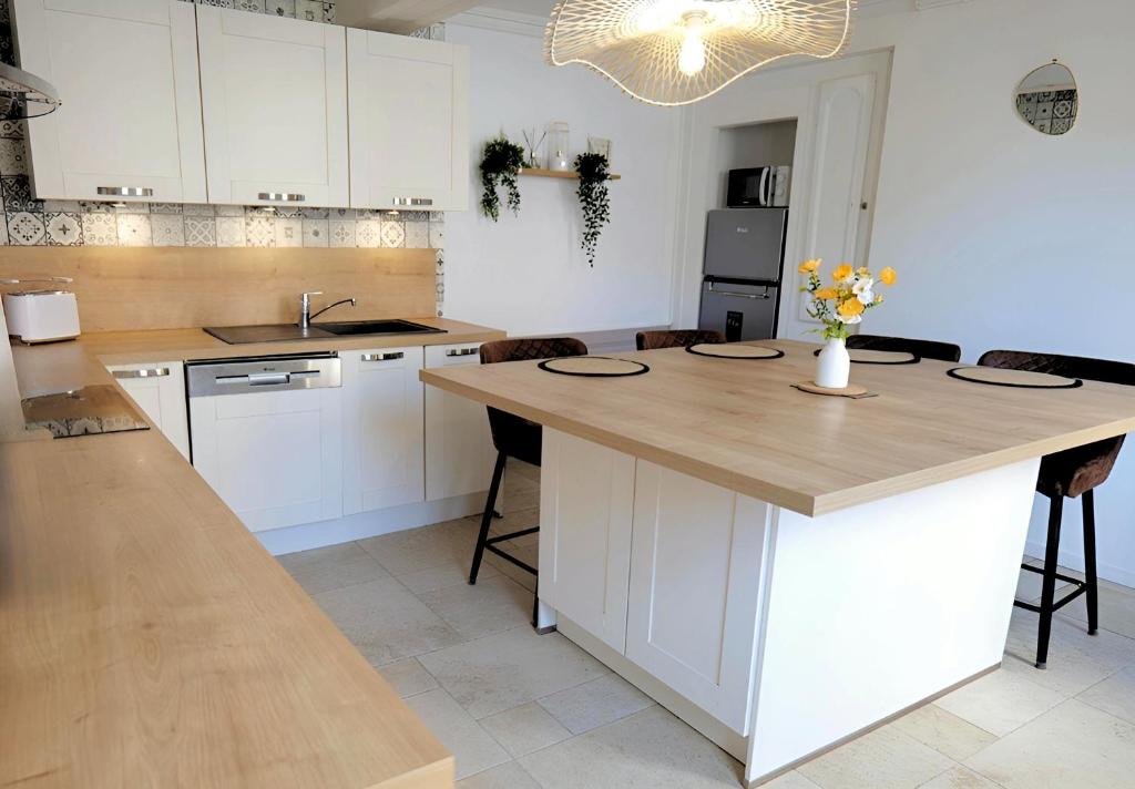 kuchnia z białymi szafkami i drewnianym blatem w obiekcie Nid Normand building 1620 - 3 bedrooms - hyper center w mieście Pont-Audemer