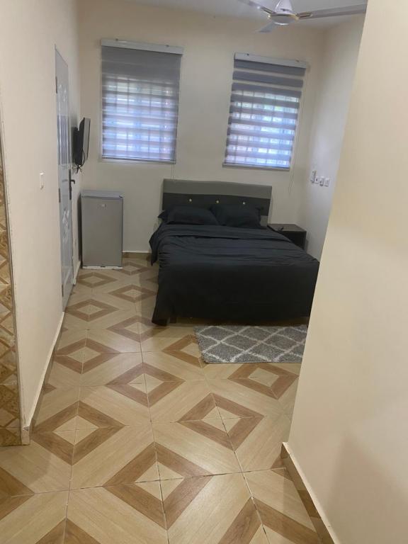 KwabenyaにあるLouis Apartmentsのベッドと木の床のある寝室