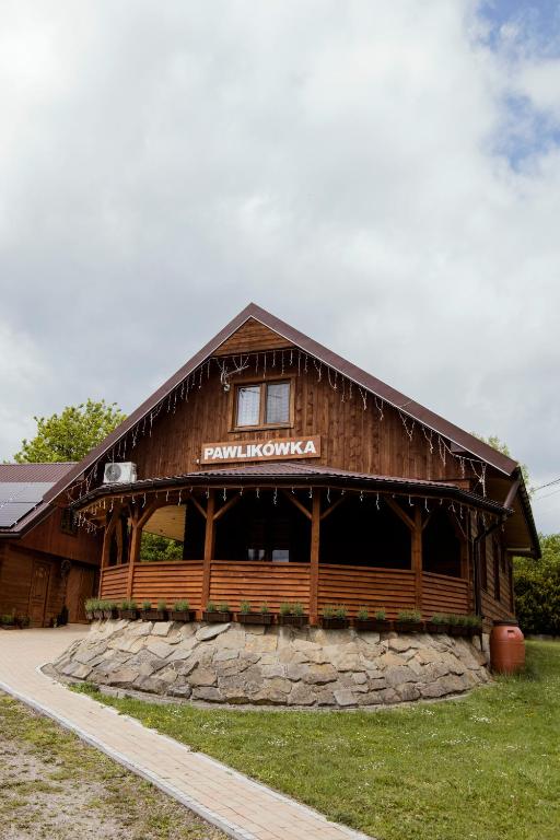 a large wooden barn with a sign on it at Agroturystyka Pawlikówka in Lipniki