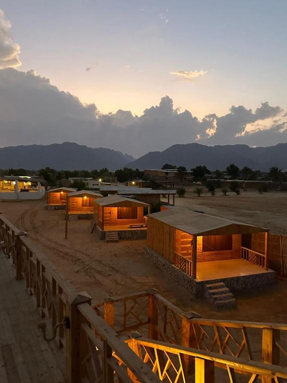 a view of a group of buildings with the sunset in the background at Seavia Camp in Nuweiba