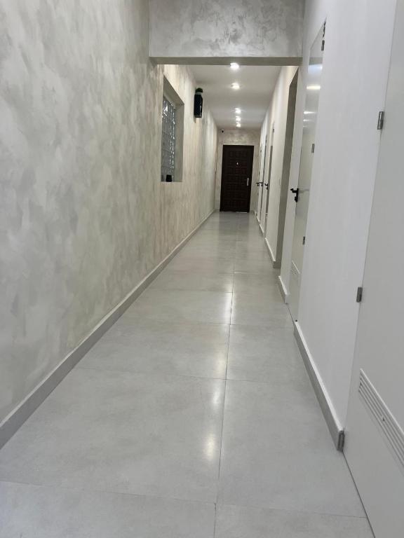 an empty hallway with white walls and a long white floor at Casa Paraíso in Adeje