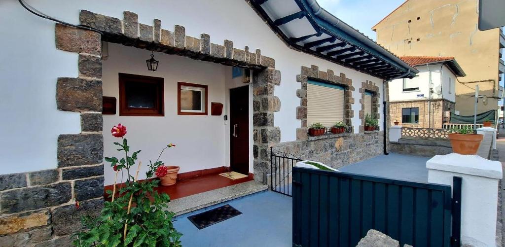 ein kleines Haus mit einem Tor und einem Balkon in der Unterkunft El Rincón de Silvia in Villaviciosa