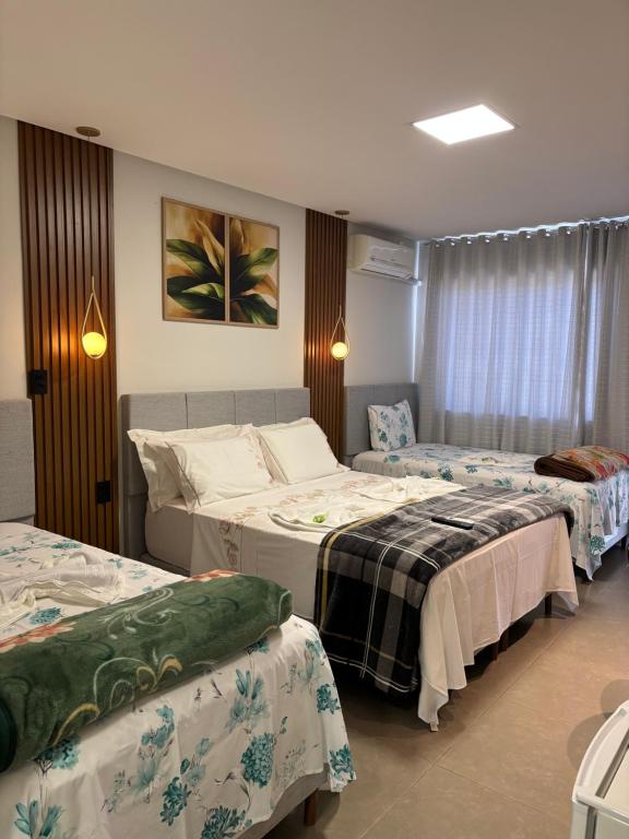 una camera d'albergo con tre posti letto di Dinho's Hotel e Restaurante a Nazareno