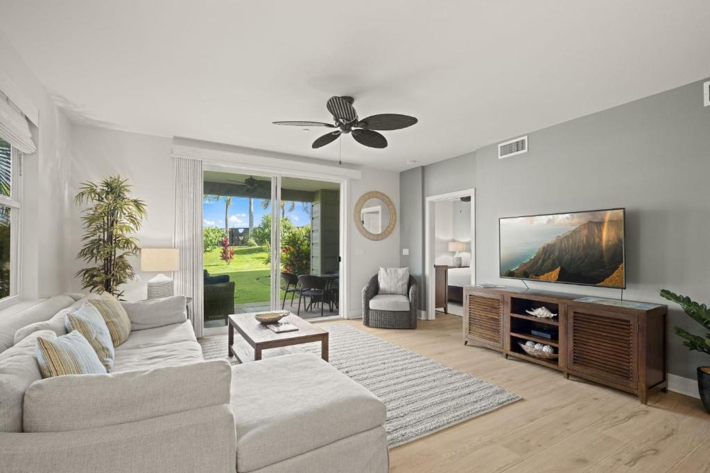 a living room with a couch and a flat screen tv at Pili Mai 5D condo in Koloa