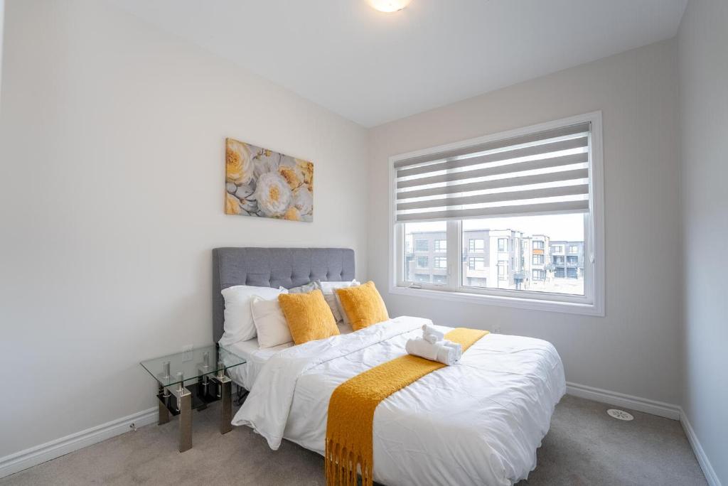 a bedroom with a bed with yellow pillows and a window at Luxury Comfort in Vaughan in Vaughan