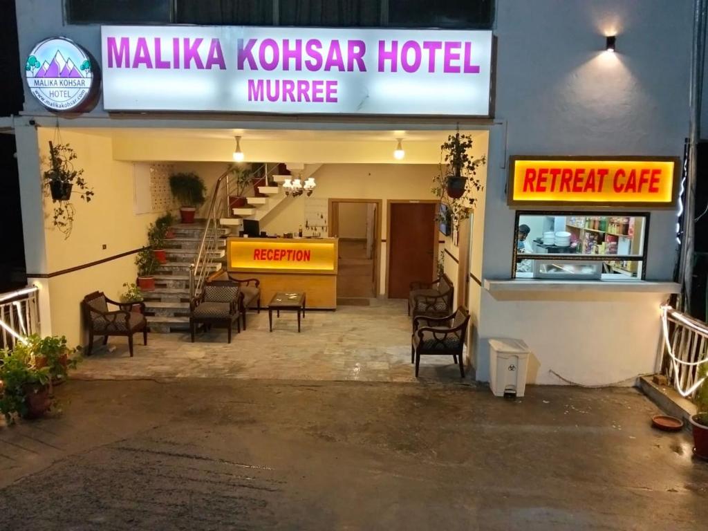 a lobby of a hotel with chairs and a restaurant at Malika Kohsar Hotel Murree in Murree