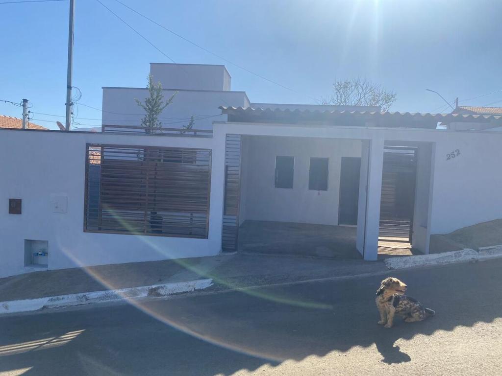 a dog sitting in front of a house at Casa Bela Vista II in São Roque de Minas