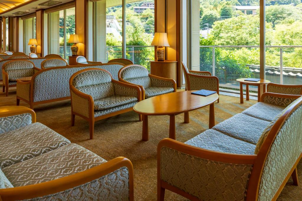 a waiting room with chairs and tables and windows at Hakone Yumoto Onsen Hotel Kajikaso in Hakone