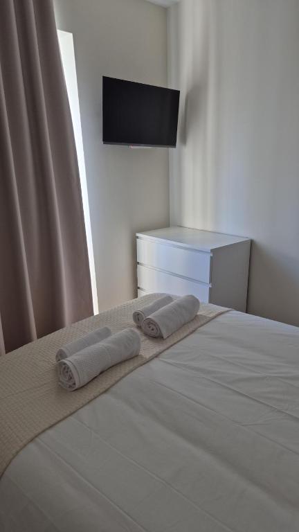 a bedroom with a bed with two towels on it at Mira Serra Hostel in Caria