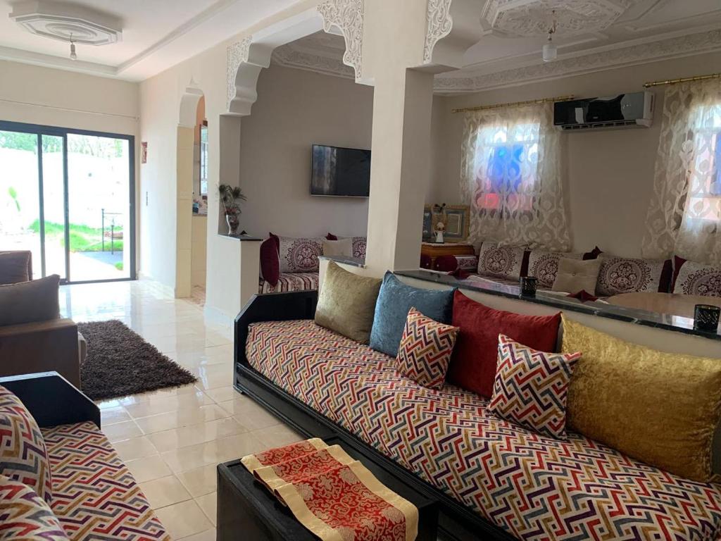 a living room with a couch with colorful pillows at paradis in Aït Bou Setta