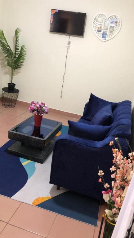 a living room with a blue couch and a table at Sacha studio chic etoug ebe in Yaoundé