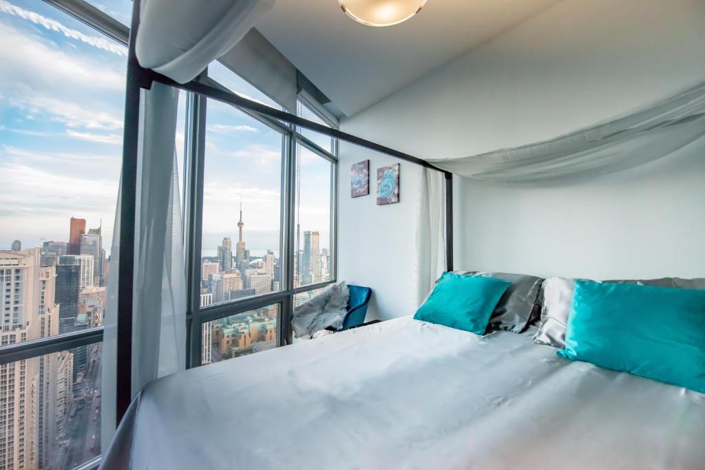a large bed in a room with a large window at Urban Skyline in Toronto
