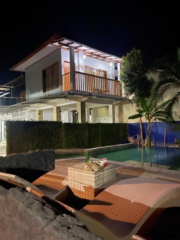 a house with a swimming pool at night at Tri Putri Kuta Homestay in Kuta Lombok