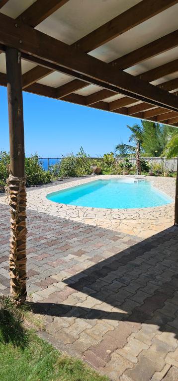 une grande piscine avec une pergola en bois dans l'établissement Chambres au sommet de la montagne, à Mahina