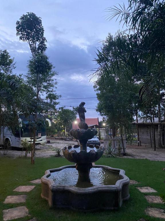 a statue of a person sitting on top of a fountain at Camping e Pousada Maloca e Rodas in Alter do Chao