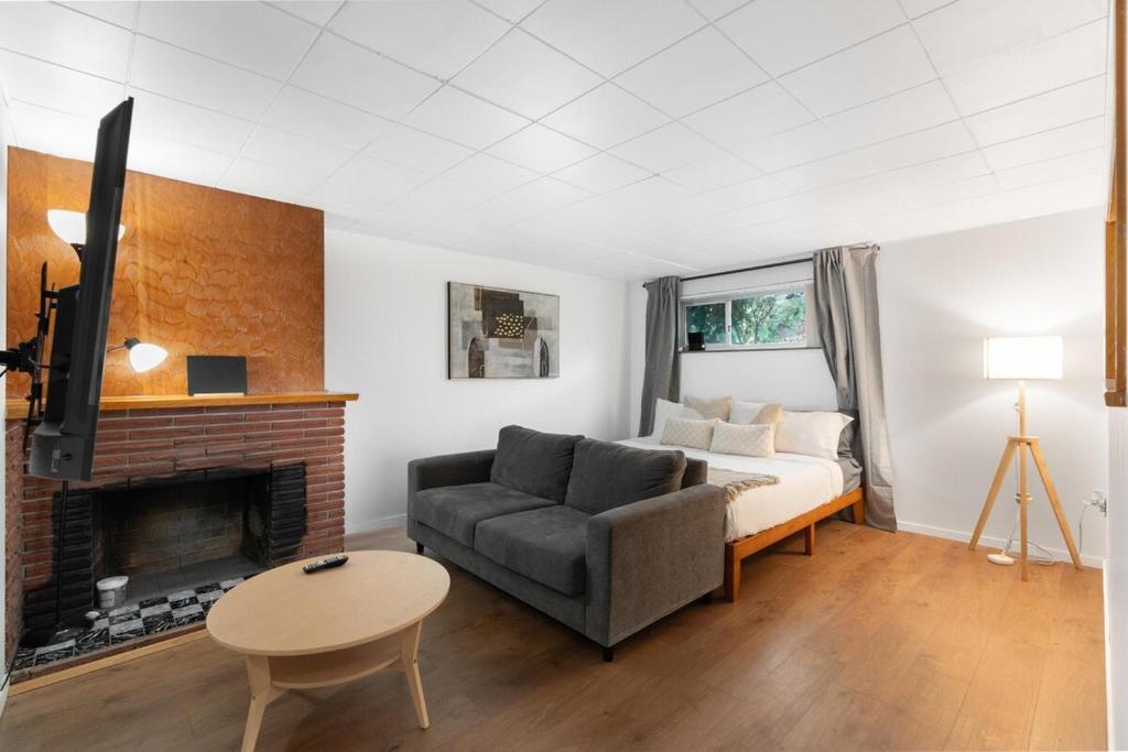 un soggiorno con divano e camino di Cozy Basement 1 BR Suite King & Queen Beds, Sleeps 6, Street Parking a Burnaby