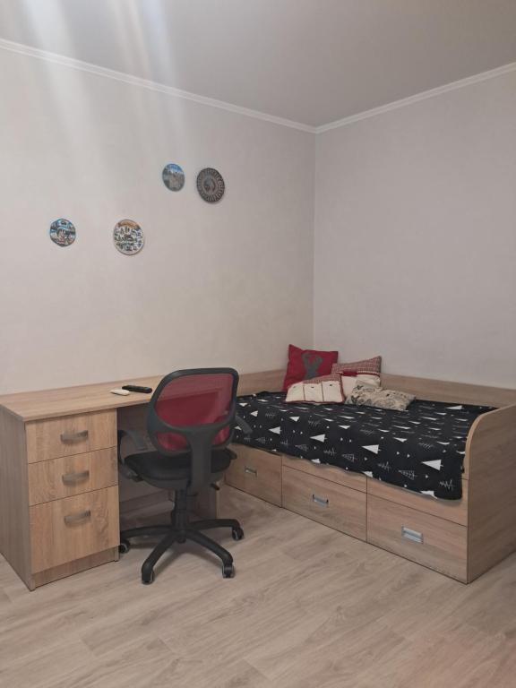 a bedroom with a bed and a desk and a chair at Apartment on Parusna, 2 in Chornomorsk