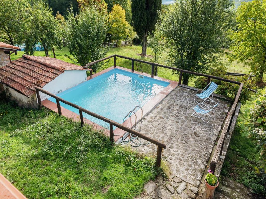 a swimming pool with two chairs in a yard at Rustic Chalet with Pool in San Marcello Pistoiese