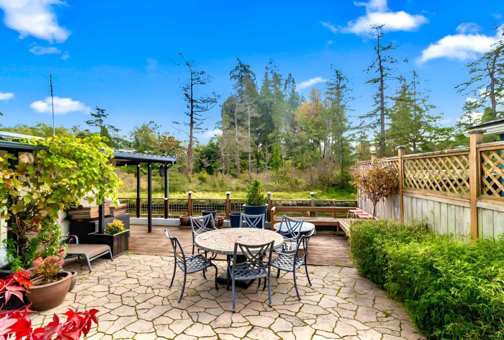 a patio with a table and chairs in a yard at Charming Cottage by Creek & Ocean in Blaine