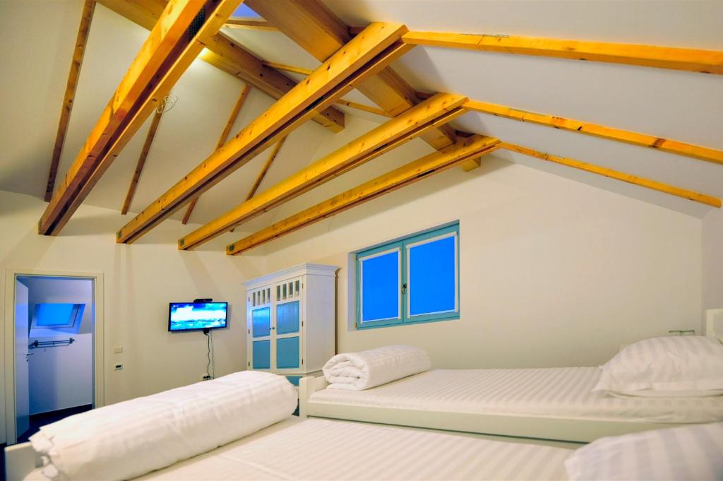 a bedroom with two beds and a flat screen tv at Pike Inn Dunavatul de Sus in Dunăvăţul-de-Sus