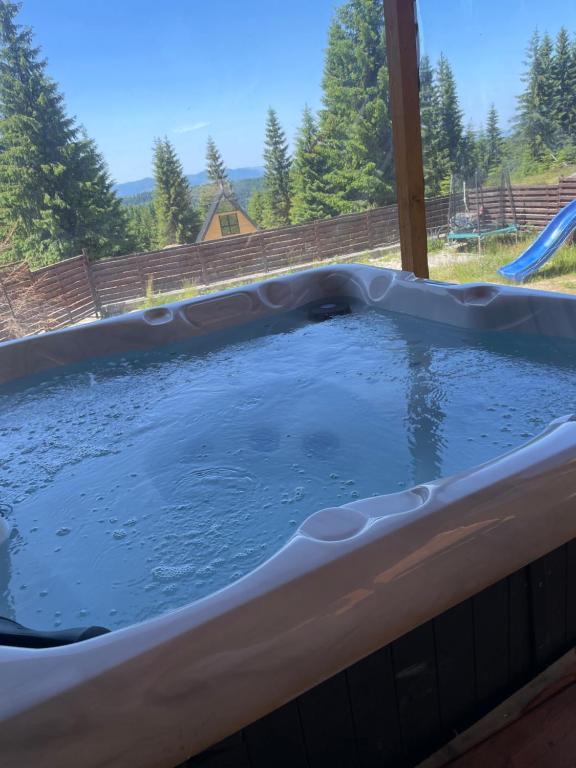 a hot tub filled with water in a backyard at 2TowersCabin in Mărişel