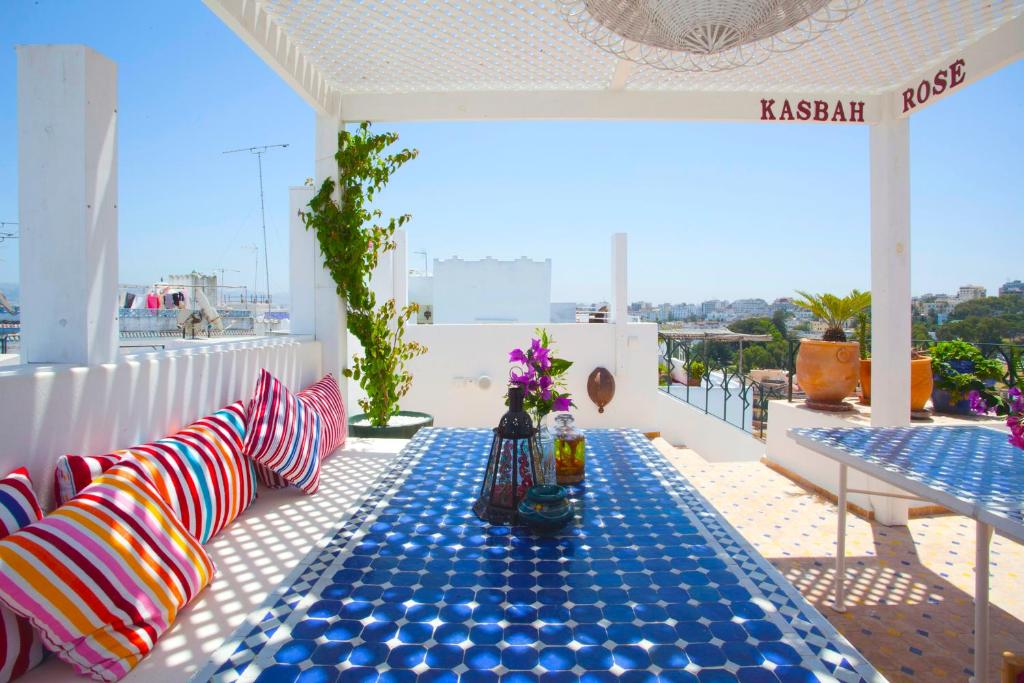 - une table avec des oreillers colorés assise sur un balcon dans l'établissement Kasbah Rose, à Tanger