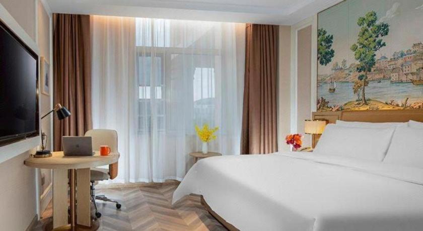 ein Schlafzimmer mit einem großen weißen Bett und einem Fenster in der Unterkunft Vienna Hotel Beijing Changping Science and Technology Park in Ch'ang-p'ing-hsien