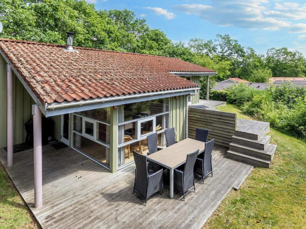 a house with a deck with a table and chairs at 6 person holiday home in Hadsund-By Traum in Øster Hurup