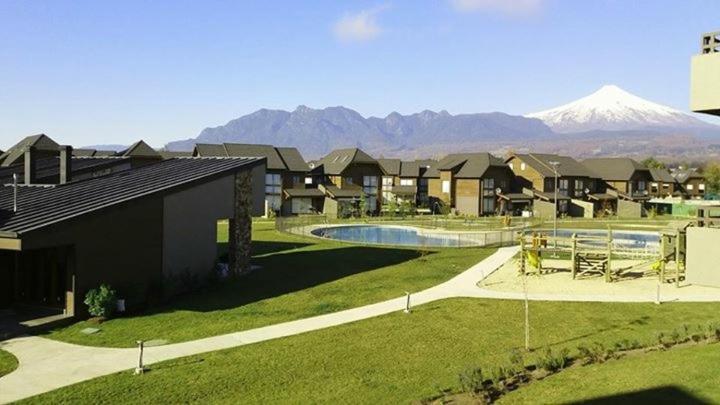 a house with a pool with a mountain in the background at Departamento Costa Pucon in Pucón