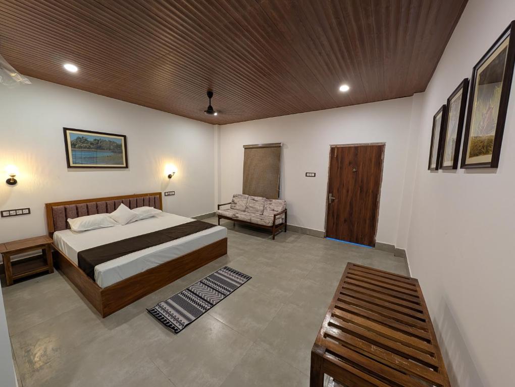 a bedroom with a bed and a chair in it at Mangrove Forest Camp Eco Stay Sundarbans, India in Jāmb
