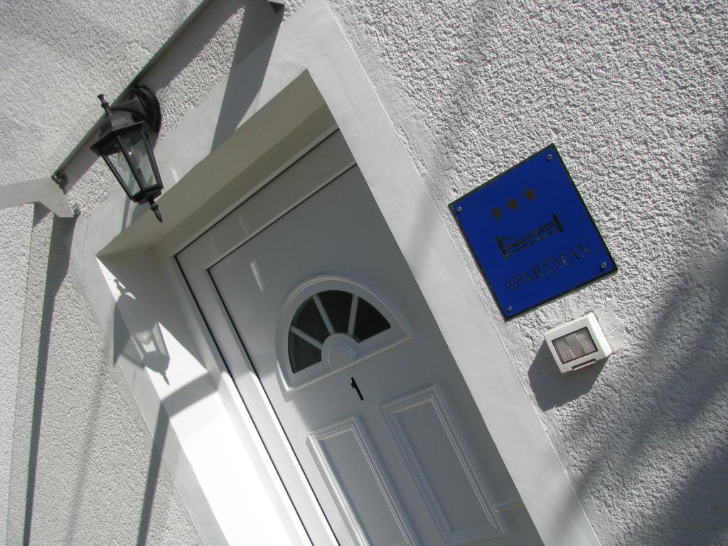 a door to a building with a blue sign on it at Apartment Sea Garden in Ičići