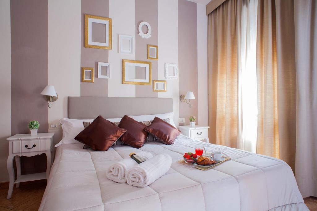 a white bed with towels and a tray of fruit on it at Hotel Ares Milano in Milan