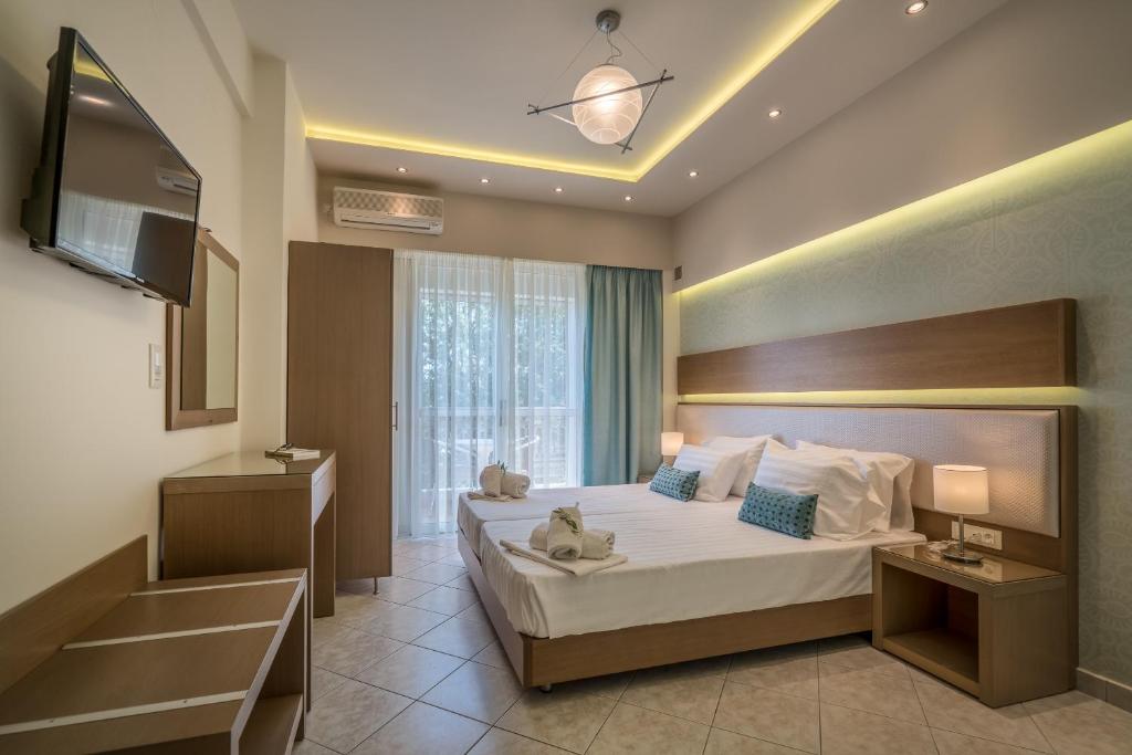 a hotel room with a bed and a television at Alba Boutique Apartments in Laganas